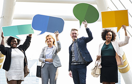 four people holding up speech bubble signs